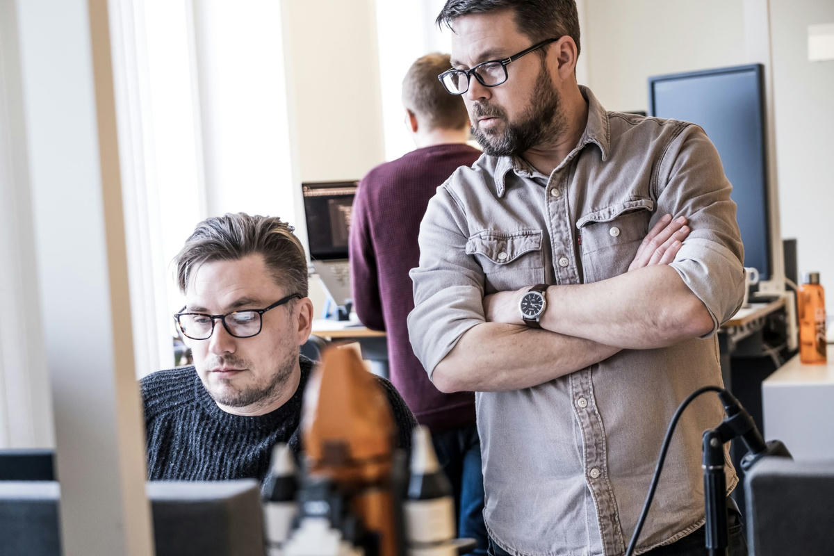 Två kollegor på TwoFour diskuterar och samarbetar vid sina datorer på kontoret. En av dem står och tittar på skärmen medan den andra sitter vid skrivbordet. Två kollegor på TwoFour diskuterar och samarbetar vid sina datorer på kontoret. En av dem står och tittar på skärmen medan den andra sitter vid skrivbordet.